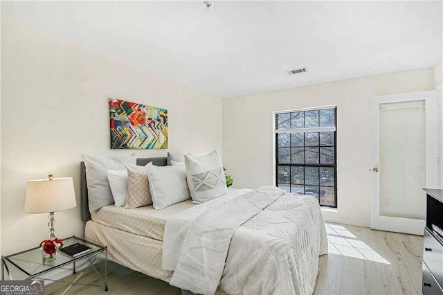 bedroom featuring visible vents, baseboards, and wood finished floors