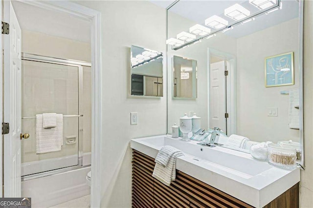 full bathroom featuring enclosed tub / shower combo, toilet, and vanity