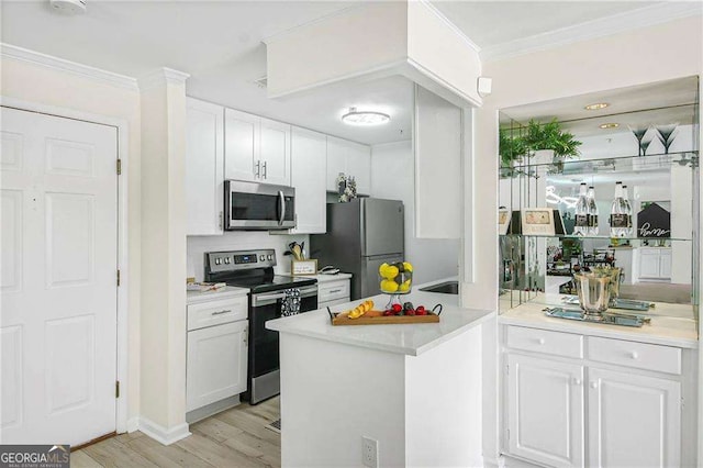 kitchen with stainless steel appliances, light countertops, white cabinets, light wood-style floors, and crown molding