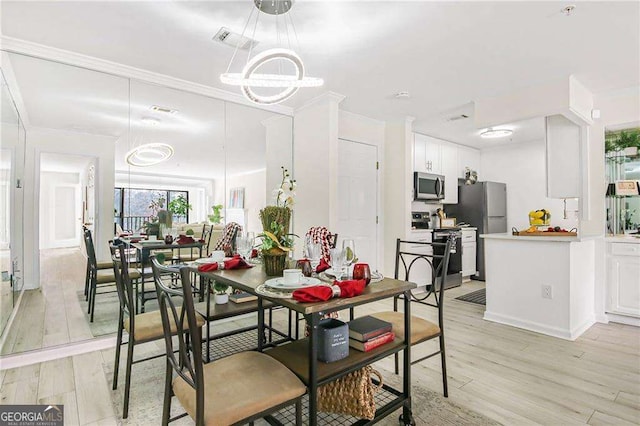 dining space with light wood-type flooring, visible vents, and ornamental molding