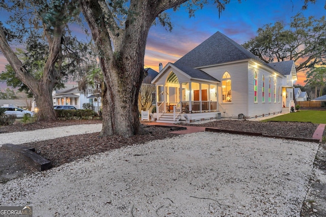 view of front of home with roof with shingles and covered porch