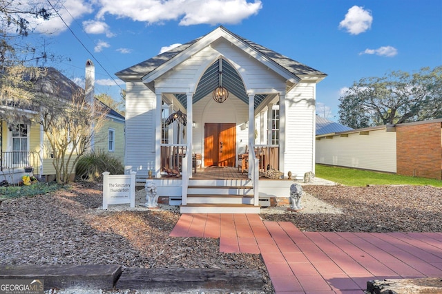 view of front of property with a porch and roof with shingles