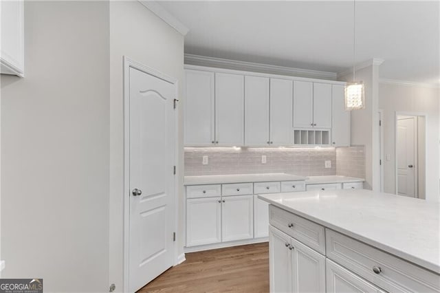 kitchen with white cabinets, crown molding, and light countertops