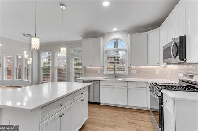 kitchen featuring a sink, light countertops, white cabinets, appliances with stainless steel finishes, and tasteful backsplash