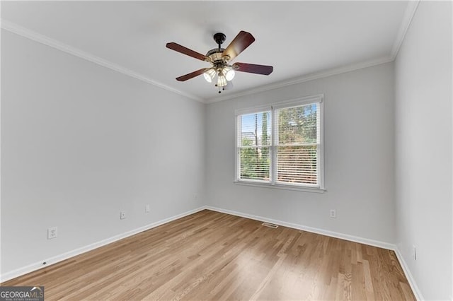 spare room with light wood-type flooring, baseboards, ceiling fan, and crown molding