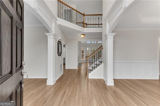 1900 Sanborne Way, Dacula, GA 30019 - entryway featuring decorative columns, light wood-style flooring, stairs, baseboards, and arched walkways