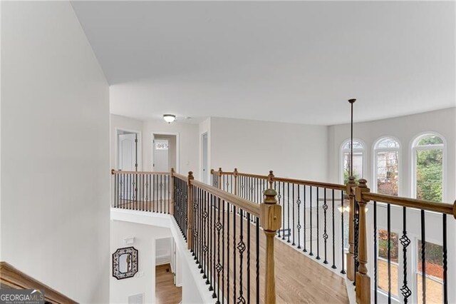 hall featuring an upstairs landing and light wood-style flooring