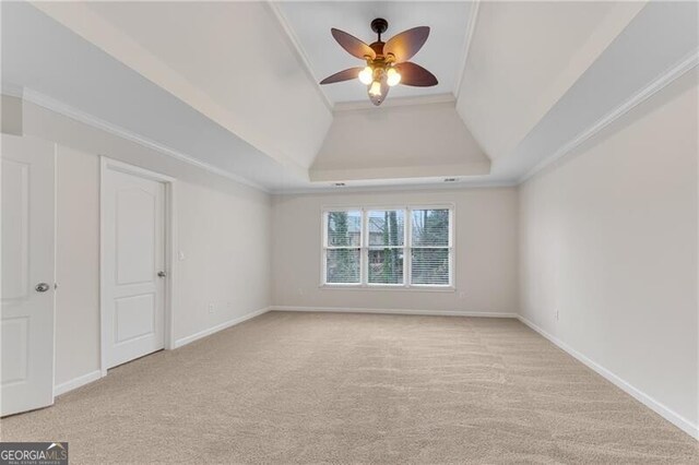 empty room with light carpet, a ceiling fan, baseboards, and ornamental molding