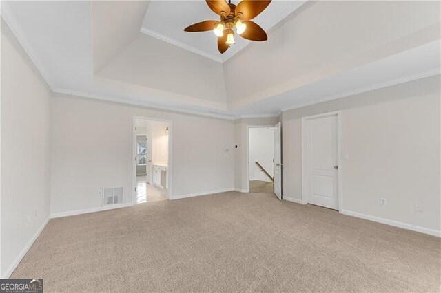 empty room with visible vents, a ceiling fan, carpet, crown molding, and baseboards