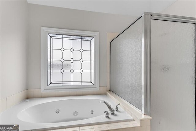 full bath featuring a tub with jets and a shower stall