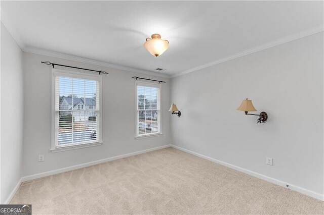 empty room featuring baseboards, carpet, and ornamental molding