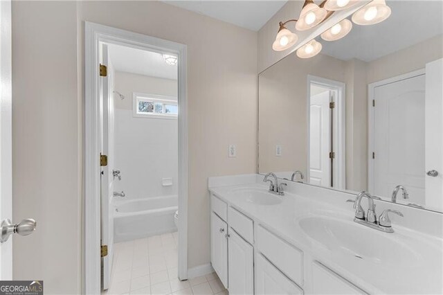 full bath with double vanity, tile patterned floors, toilet, and a sink