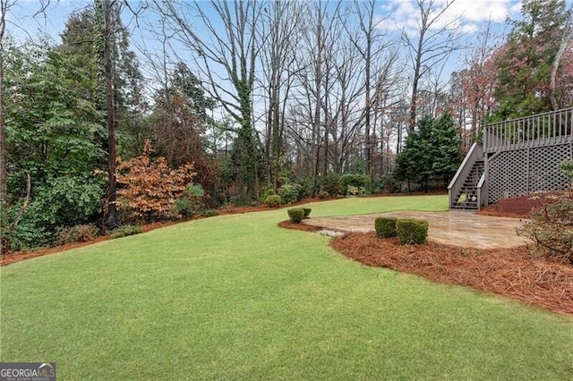 view of yard with a patio, stairway, and a wooden deck