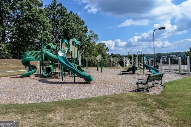 community play area featuring a lawn and fence