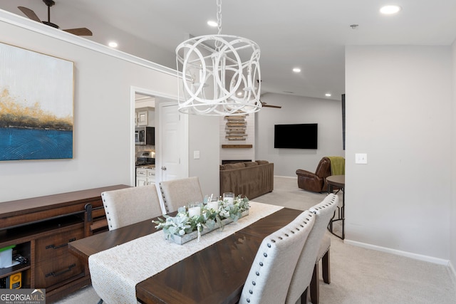 dining space with recessed lighting, light colored carpet, and ceiling fan with notable chandelier