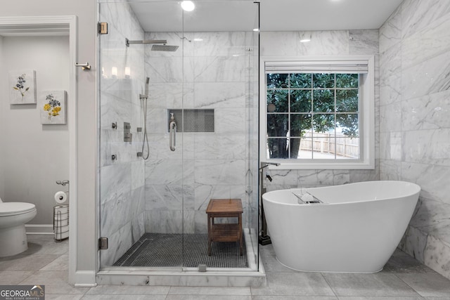 bathroom featuring toilet, a stall shower, and a freestanding bath