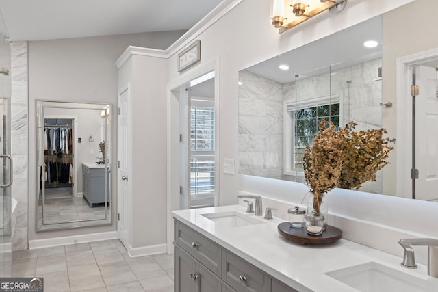 full bathroom featuring double vanity, a stall shower, a walk in closet, and a sink