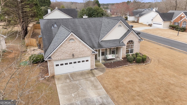 traditional home with brick siding, concrete driveway, roof with shingles, covered porch, and an attached garage