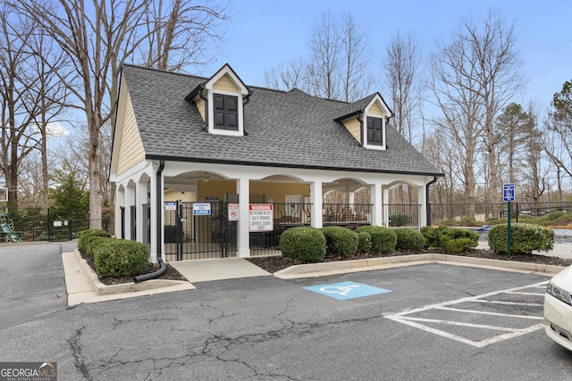 view of building exterior featuring fence and uncovered parking