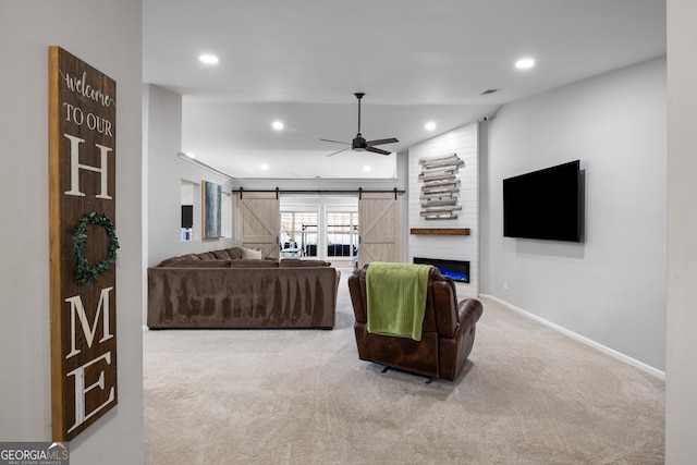 living area with baseboards, recessed lighting, ceiling fan, a barn door, and carpet flooring