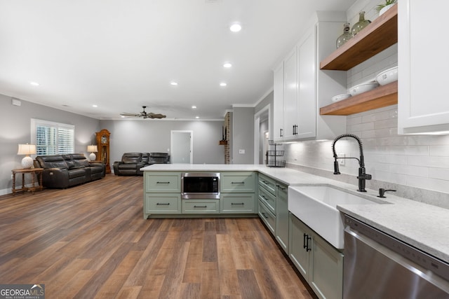 kitchen with green cabinetry, open shelves, built in microwave, a sink, and dishwasher