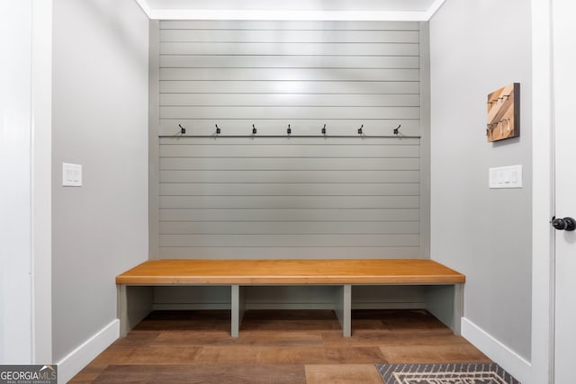 mudroom featuring wood walls, baseboards, and wood finished floors