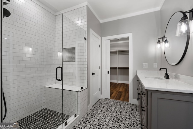 bathroom with vanity, a stall shower, ornamental molding, a spacious closet, and tile patterned floors