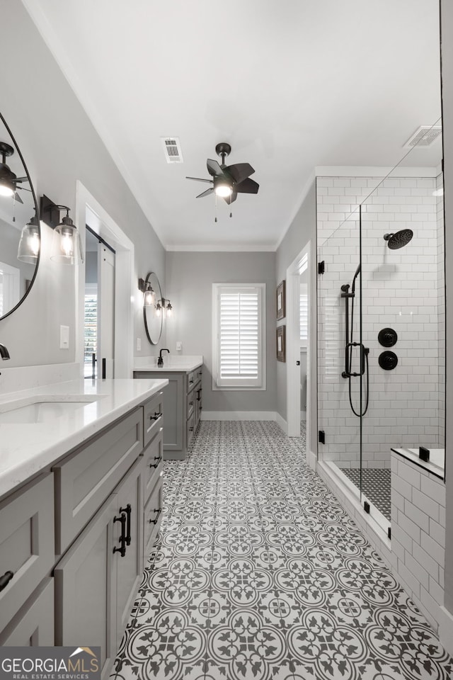 bathroom featuring a wealth of natural light, visible vents, a ceiling fan, a sink, and a shower stall