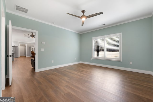 spare room featuring visible vents, dark wood-style floors, and crown molding