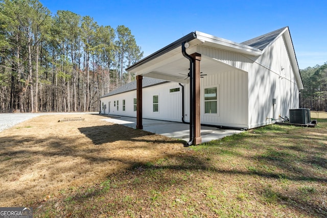 view of side of home with a patio, cooling unit, and a lawn