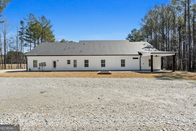 rear view of property featuring roof with shingles