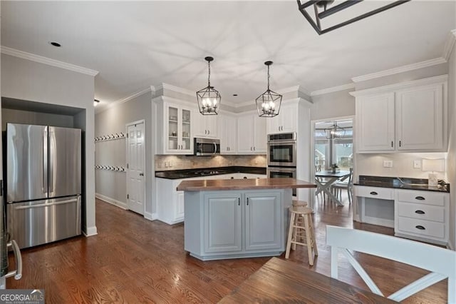 kitchen with dark wood-style floors, appliances with stainless steel finishes, wood counters, white cabinetry, and a center island