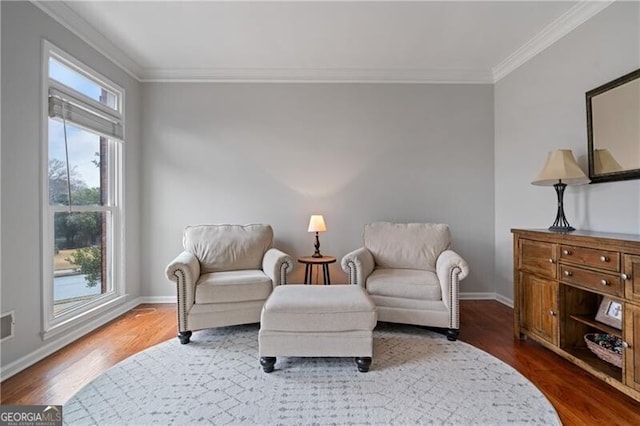 living area featuring ornamental molding, baseboards, and wood finished floors