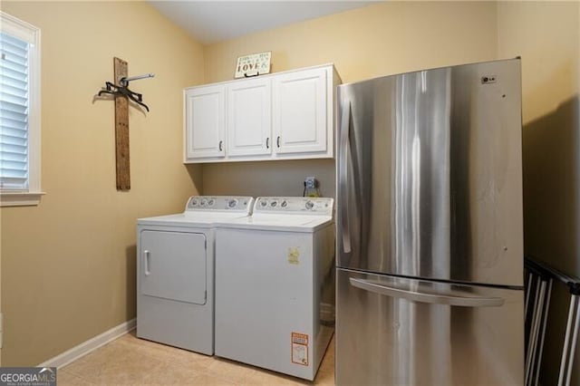 laundry room featuring cabinet space, baseboards, and washing machine and clothes dryer