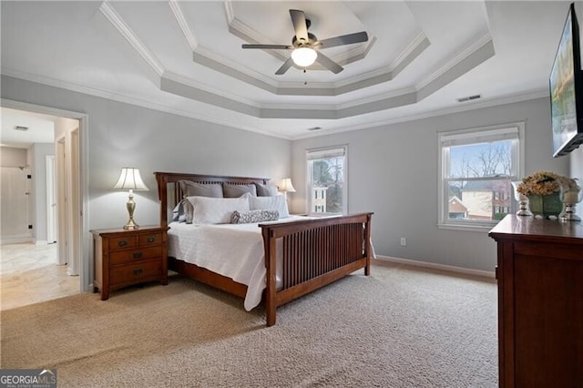 carpeted bedroom featuring a raised ceiling, baseboards, visible vents, and ornamental molding