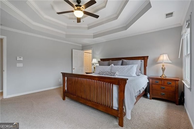 bedroom with visible vents, baseboards, a tray ceiling, ornamental molding, and carpet floors