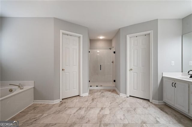 bathroom with marble finish floor, a shower stall, baseboards, a bath, and vanity