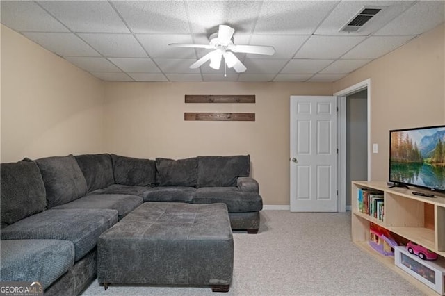 living room featuring visible vents, a ceiling fan, a drop ceiling, carpet flooring, and baseboards