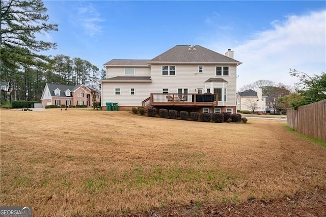 back of house featuring a yard, fence, a chimney, and a wooden deck