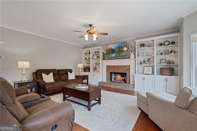 living room featuring a ceiling fan, light wood-style flooring, a fireplace, and ornamental molding