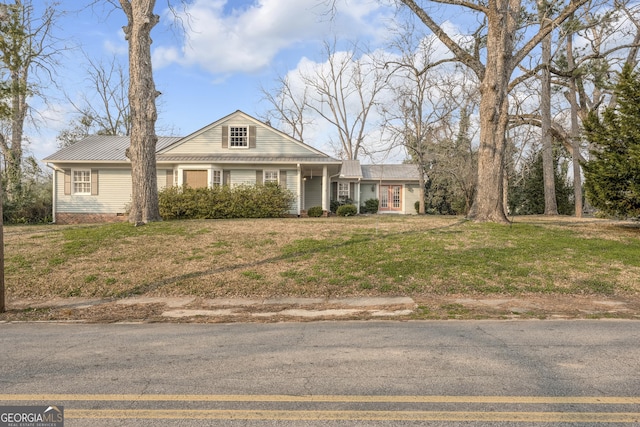 view of front of house with metal roof and a front yard