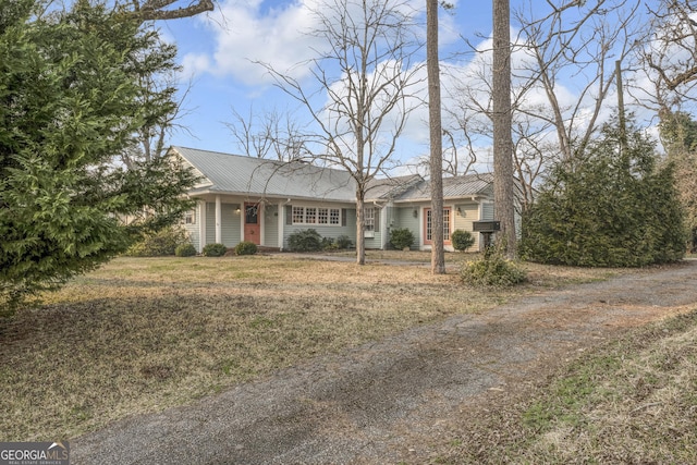 ranch-style house with metal roof and a front yard