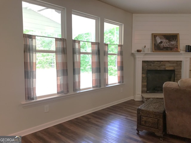 living room featuring baseboards, dark wood finished floors, and a fireplace