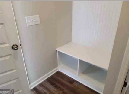 mudroom featuring baseboards and dark wood-style flooring