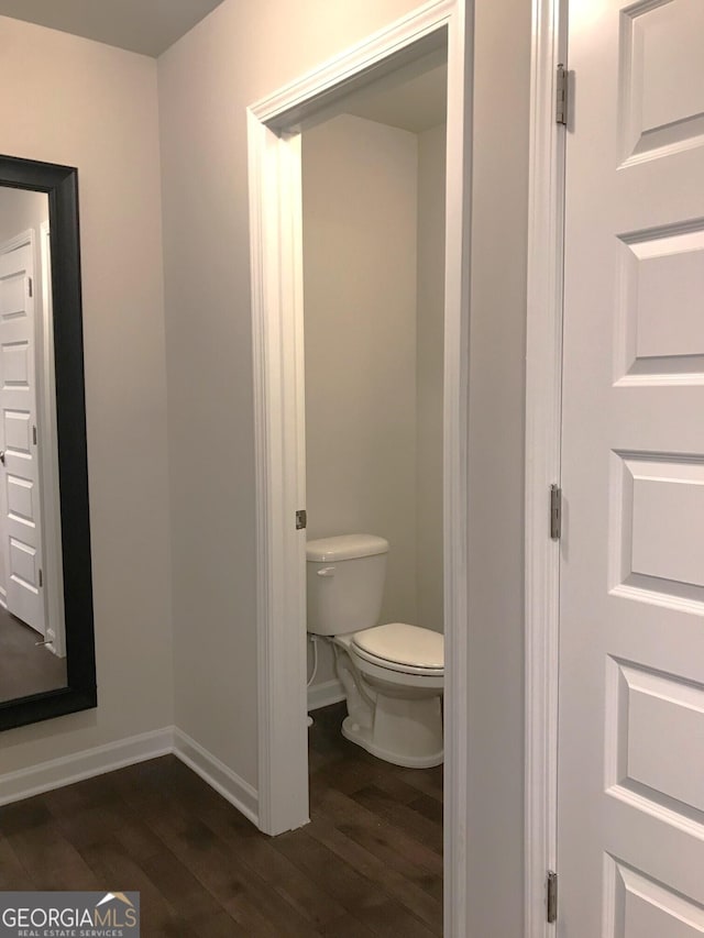 bathroom with toilet, wood finished floors, and baseboards