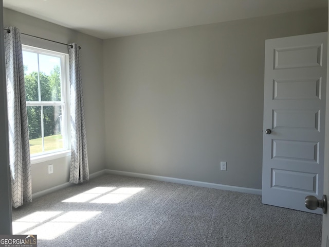 empty room with baseboards and carpet