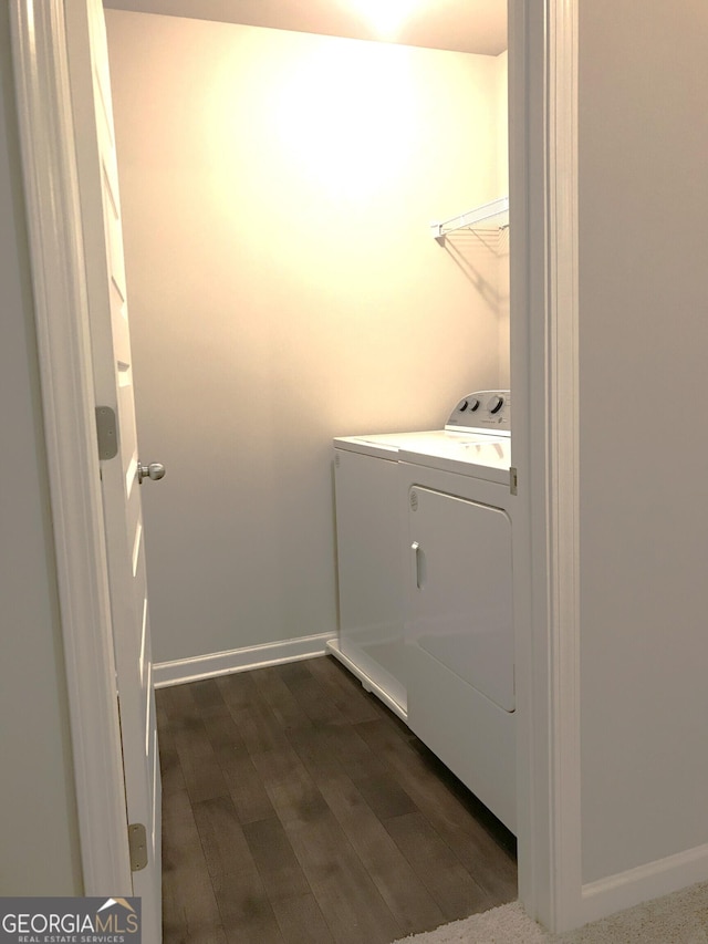 washroom with dark wood finished floors, laundry area, baseboards, and washer and clothes dryer