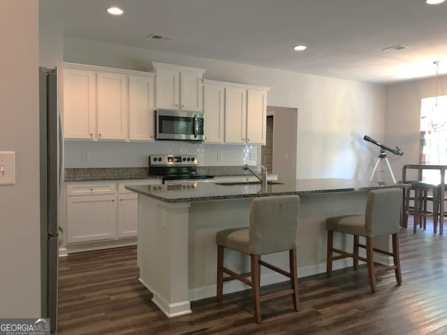 kitchen with a sink, visible vents, white cabinetry, and stainless steel appliances