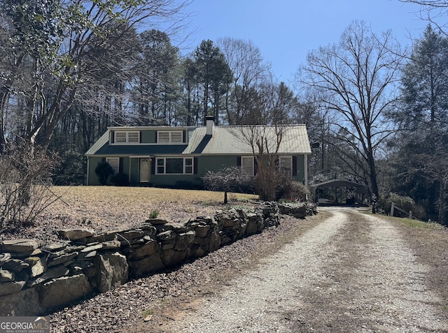 view of front of home featuring driveway and a chimney