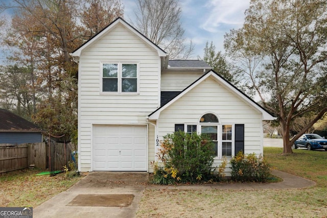 traditional-style home featuring driveway, an attached garage, and fence